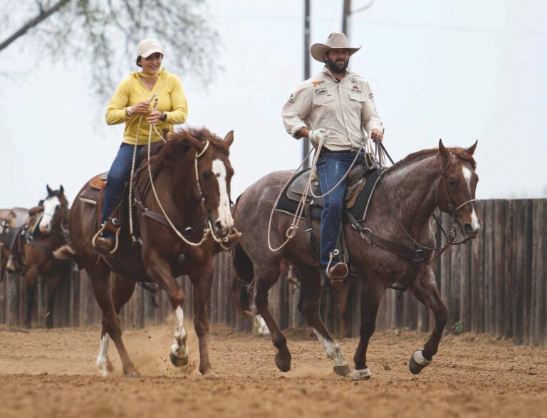 Dakota Kirchenschlager riding in an arena with his wife Emily.